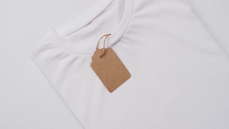 Video-of-white-folded-t-shirt-with-tag-and-copy-space-on-white-background