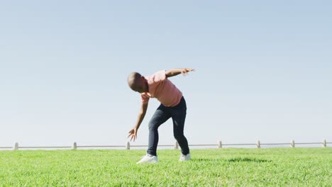 video of happy african american boy doing cartwheel outdoors