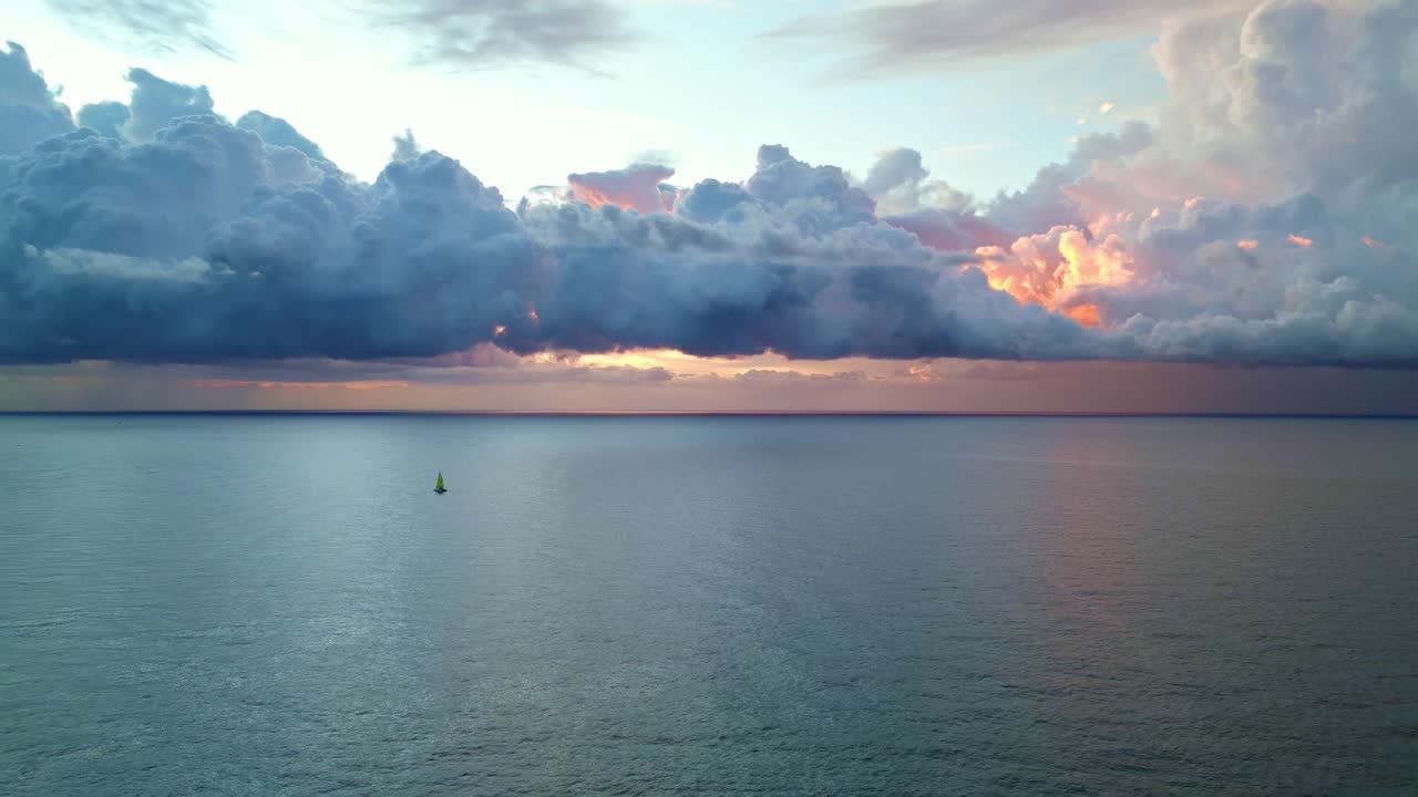 un barco solitario navegó por el mar con una nube roja sobre él