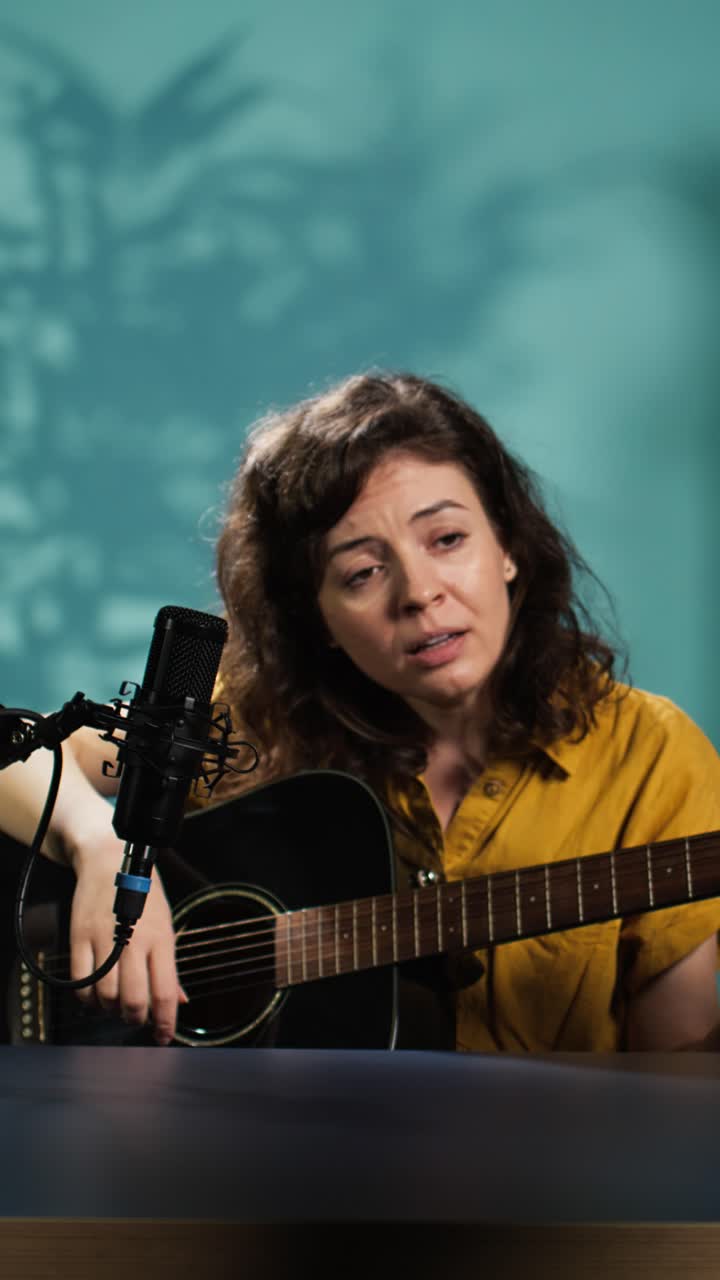 Mulher tocando violão e cantando em um microfone em estúdio
