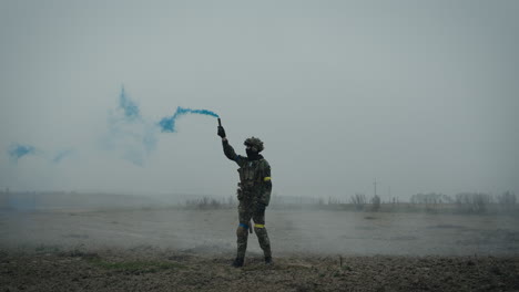 soldier in camouflage uniform with smoke grenade