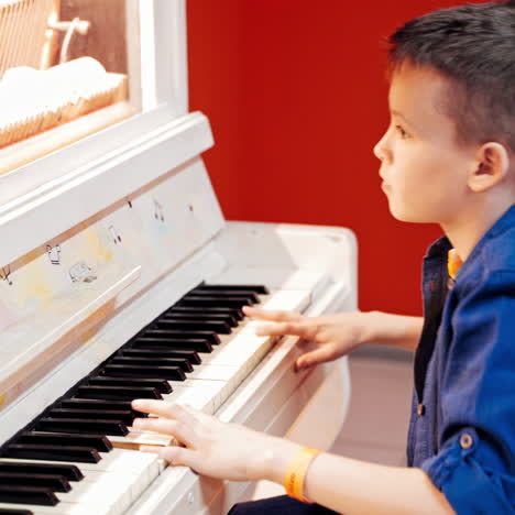 the boy plays the piano. ?hild study principle of piano in experimentanium science museum