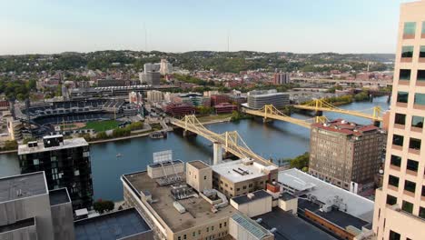 Aerial-revealing-shot-of-downtown-Pittsburgh,-to-Allegheny-River-and-city-of-bridges-over-Allegheny-River-during-autumn-magic-hour