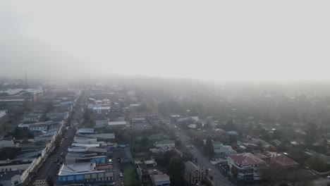 dron aéreo volando a través de las nubes sobre una ciudad en las montañas azules