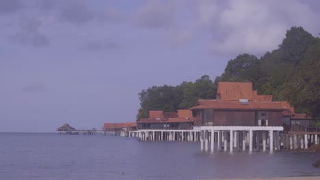 wide shot of wooden waterfront chalets on white stilts at berjaya langkawi resort