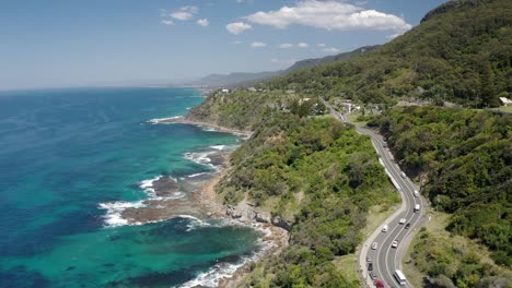 carretera de montaña con coches que viajan en el puente del acantilado del mar en un día soleado cerca de wollongong en nsw, australia