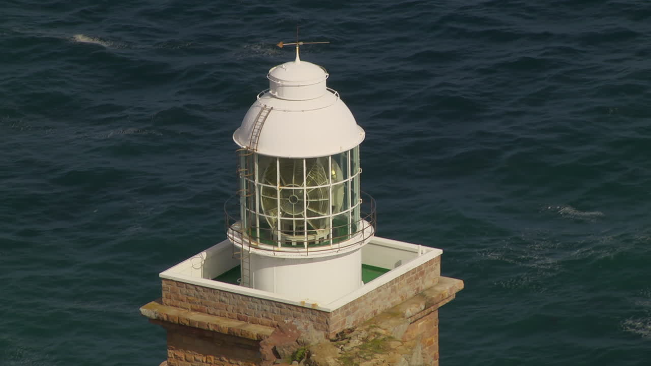 White Lighthouse Against Gently Rolling Waves In The Background. Locked Off