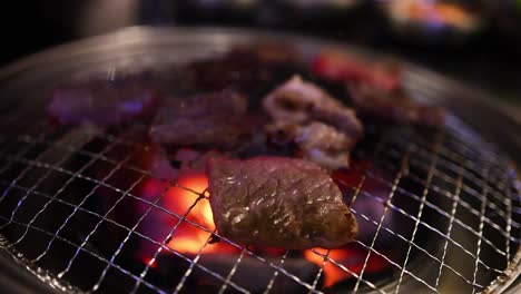 beef and bacon grilling over open flames