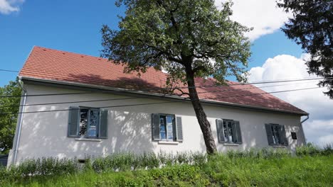 modernes landhaus mit rotem fliesendach und großen fenstern