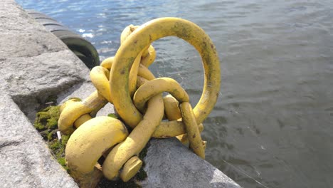 cadena amarilla utilizada para amarrar barcos en un día soleado en la orilla