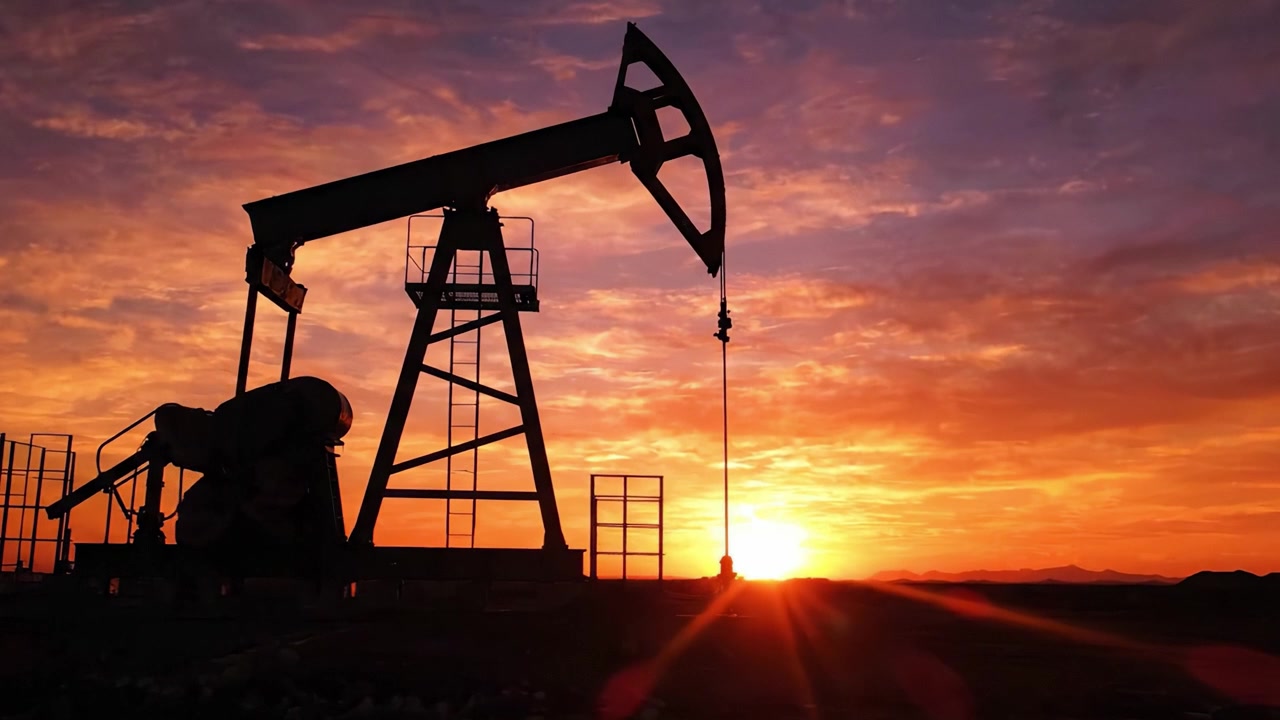A Beautiful Sunset Over an Oil Pump Jack: Capturing the Serene Beauty of Energy Extraction Amidst Nature's Vibrant Colors