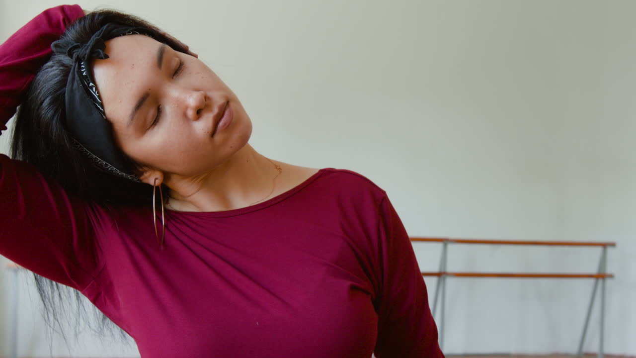 Mujer estirándose y expresándose en un estudio