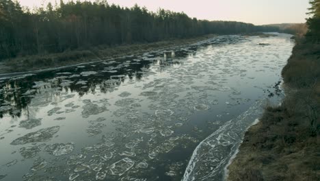 ice chunks going slow river down stream in sunny winter day