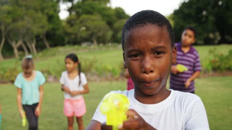 Portrait-of-smiling-boy-playing-with-water-gun