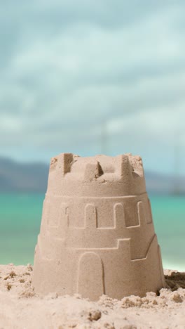 video concepto de vacaciones de verano vertical haciendo castillo de arena en la playa de arena contra el fondo del mar