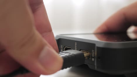 inserting hdmi cable into the side port of external monitor closeup