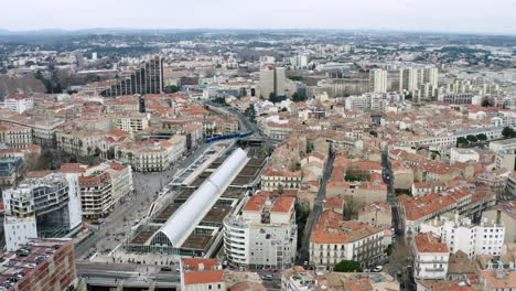 Volando-Alrededor-De-La-Vista-Aérea-De-La-Estación-De-Tren-De-Montpellier.-Tranvía-Llegando-A-La-Ciudad