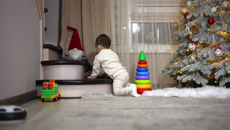 baby playing near christmas tree