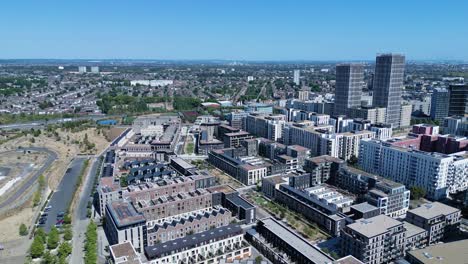 Aerial-view-flying-above-Stratford-London-downtown-district-cityscape-skyscraper-office-blocks-under-blue-sky