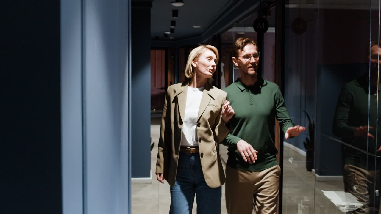 Business professionals walking and discussing in a modern office hallway