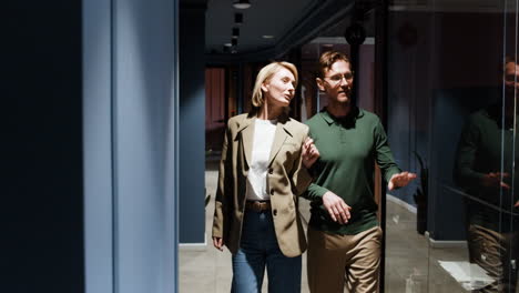 business professionals walking and discussing in a modern office hallway