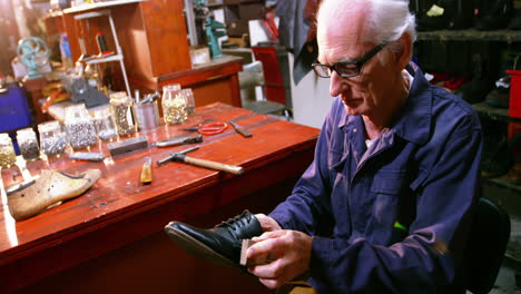 shoemaker polishing a shoe