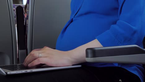 Pregnant-woman-using-laptop-while-riding-train