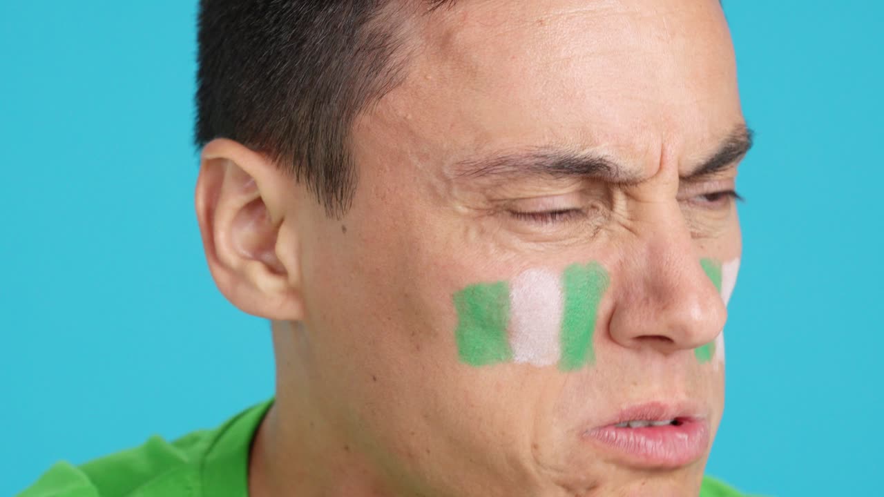 Man with nigerian national flag upset with a referee