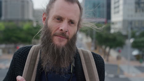 portrait-mature-bearded-hippie-man-wearing-backpack-enjoying-urban-travel-on-warm-sunny-day-in-city-slow-motion-homeless-beggar