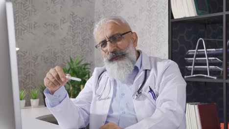 un médico sénior hablando con su paciente en videoconferencia.