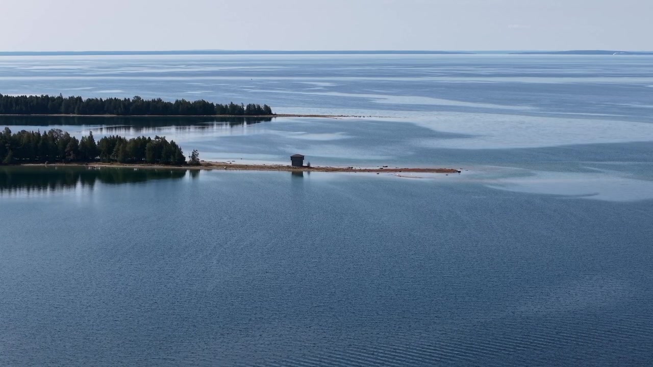 Imagem aérea de drone da margem remota de um lago com um pequeno edifício em Hessel, Michigan, com vista para o Lago Huron.