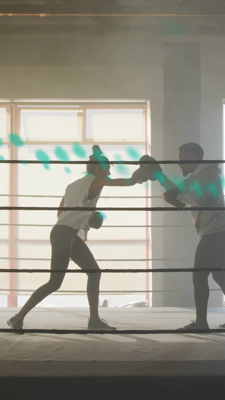 Video verticale: Allenatore che tiene i guanti da passata, pugile che misura la distanza e sferra jab in allenamento, con strisce color verde acqua che scorrono.