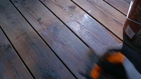 Paint-brush-treating-the-decking-with-decking-oil