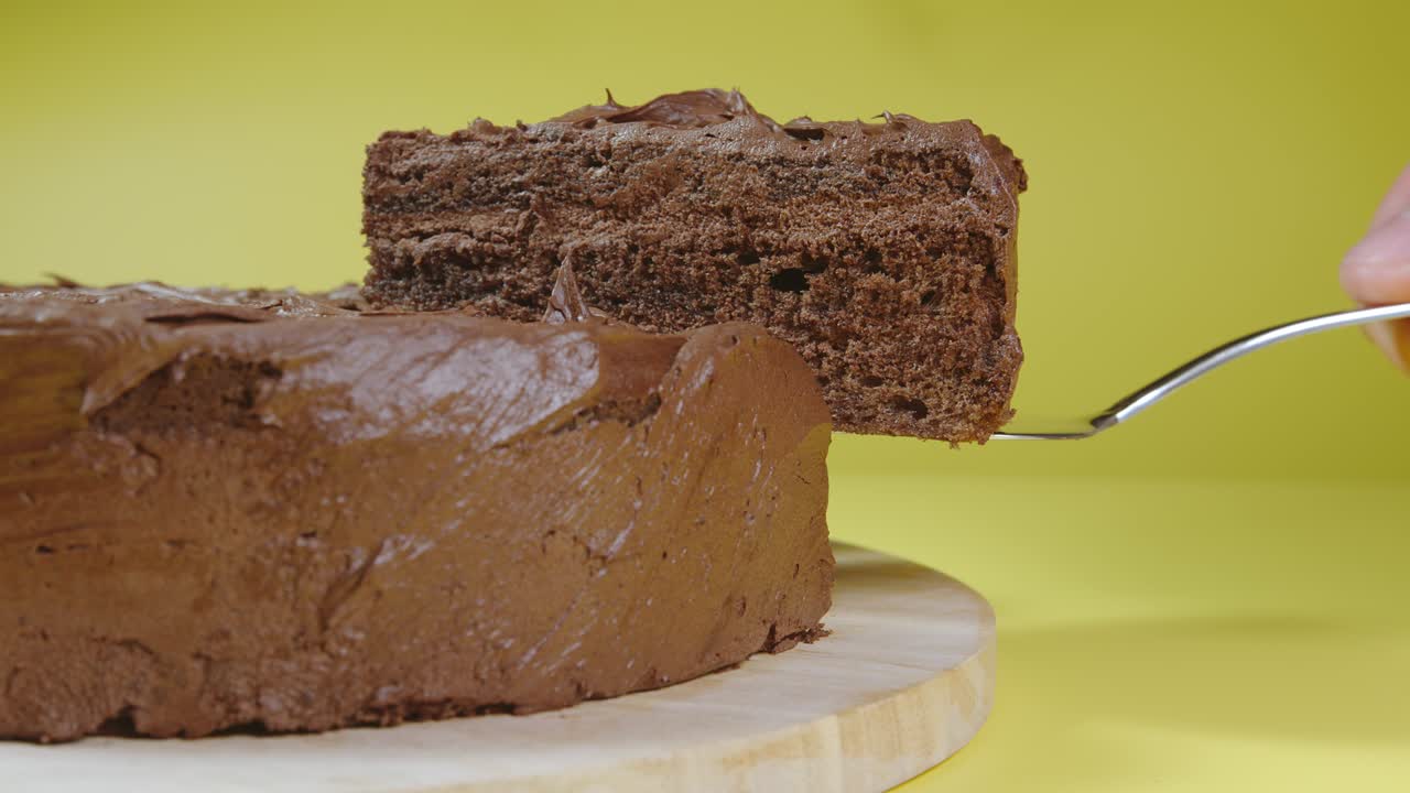 vista lateral: mano masculina recoge un pedazo de pastel de chocolate