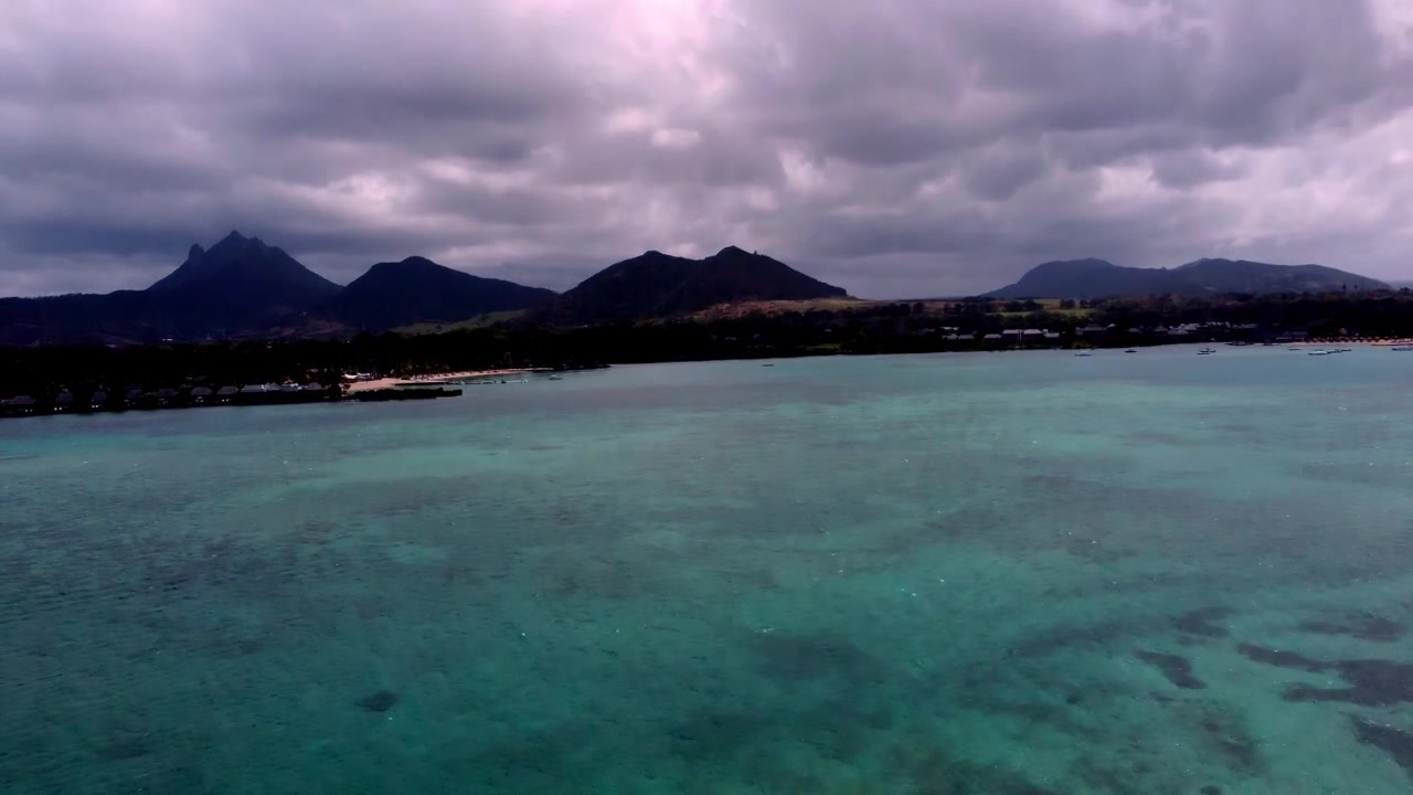Betagende luftoptagelser af stranden ved Île aux Cerfs, Mauritius, med krystalklart vand og hvidt sand.