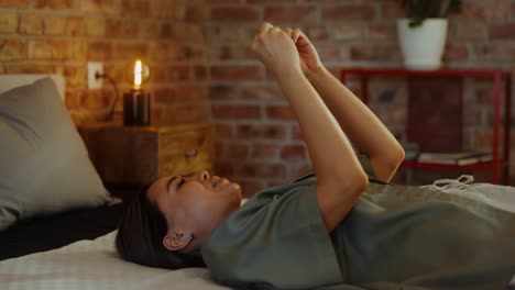 woman relaxing on bed with phone