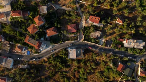 vista aérea de hermis carreteras sinuosas y casas anidadas en terreno montañoso durante la hora dorada