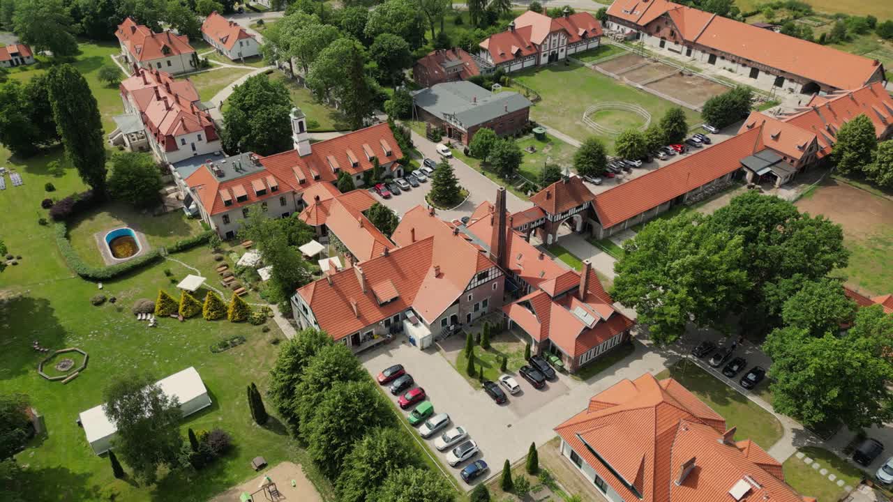 vista de un avión no tripulado de una mansión, edificios históricos, árboles y un corral de caballos