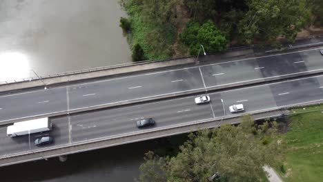 Vista-Aérea-Del-Tráfico-Que-Fluye-En-Un-Puente-Sobre-Un-Río