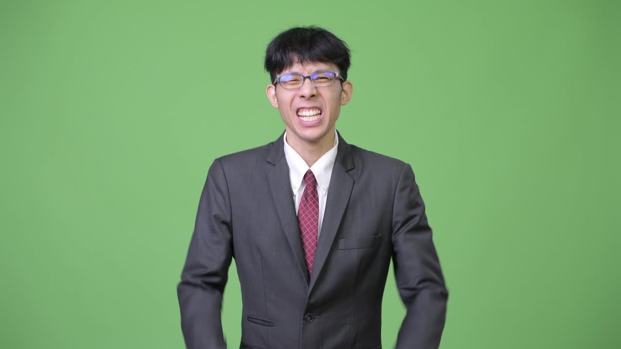 행복한 젊은 아시아 사업가 두 주먹을 높이 들고 흥분