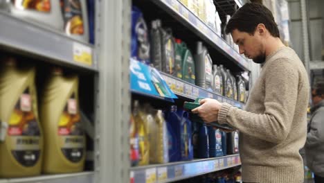 man shopping for motor oil in a grocery store