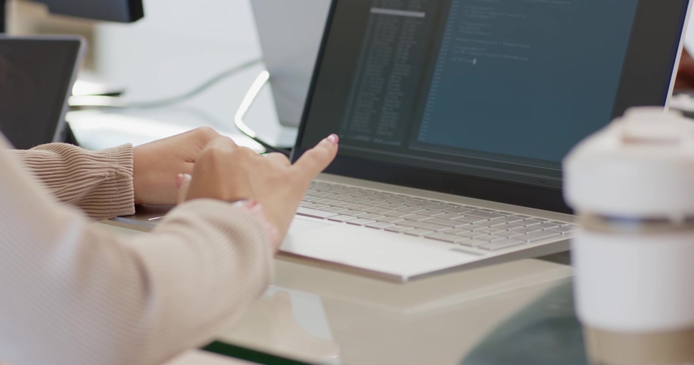 Seeing code editor, female coder typing, tapping touchpad at desk, pointing at laptop, editing code