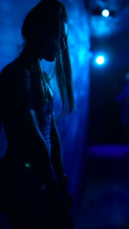 silhouette of a person in a blue-lit club at night