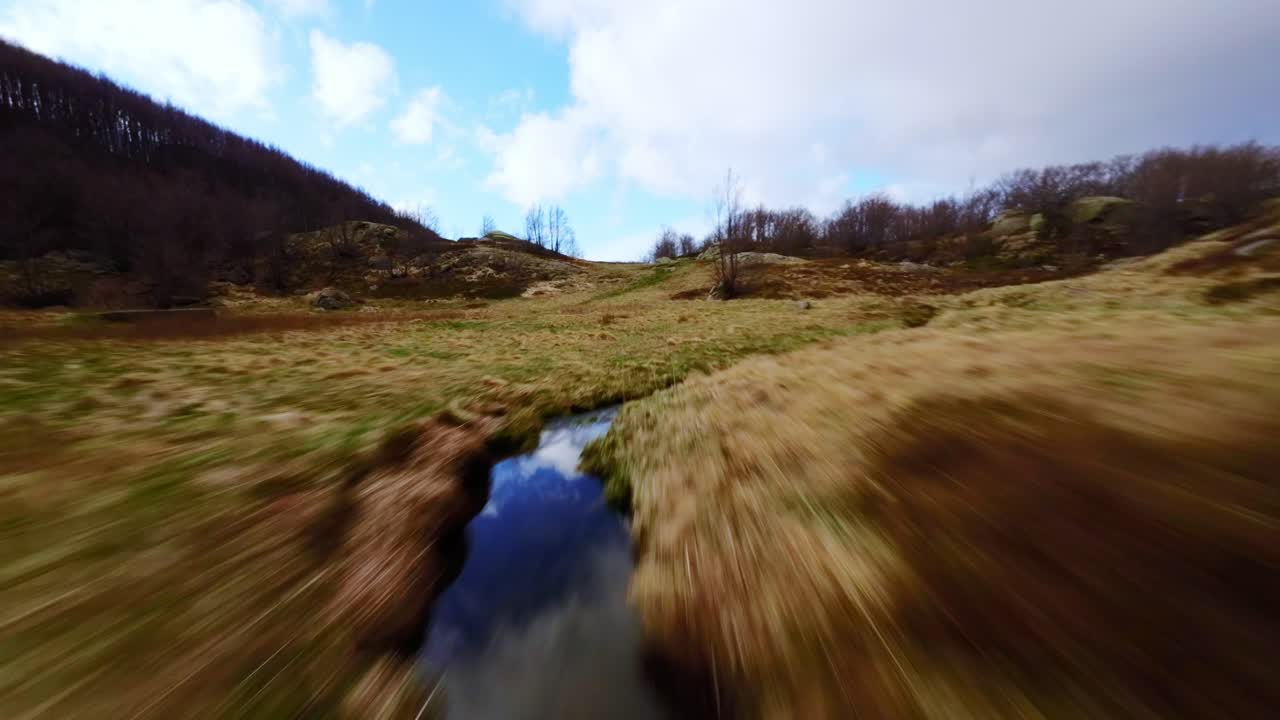Speed flight over scenic alpine meadow stream, FPV drone shot in Dolomites