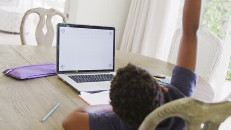 Happy african american boy using laptop for online lesson with copy space, in slow motion