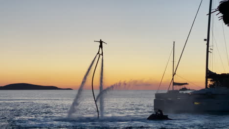 flyboard durante la puesta de sol en la isla de hvar, croacia