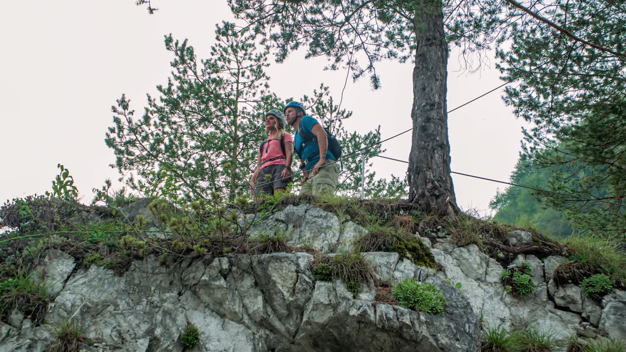 Un par de escaladores contemplando el paisaje con unas vistas increíbles desde lo alto de las rocas