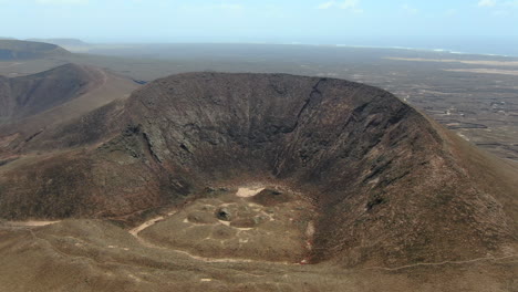 aerial drone panning right to left video footage of the calderón hondo volcano in fuerteventura island