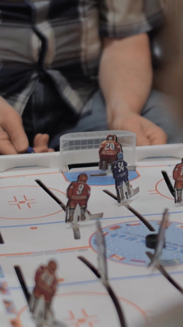 Grandpa and grandchild playing table hockey