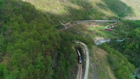 Train-ride-into-tunnel-near-Flam-town-in-Norway,-aerial-view